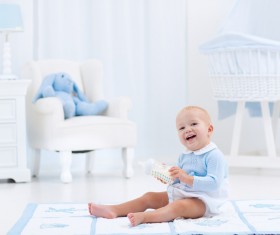 The baby sitting on the carpet is happy to play the bottle Stock Photo