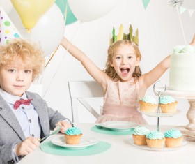 The children sitting on the birthday table Stock Photo