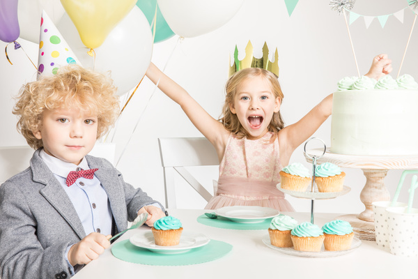 The children sitting on the birthday table Stock Photo