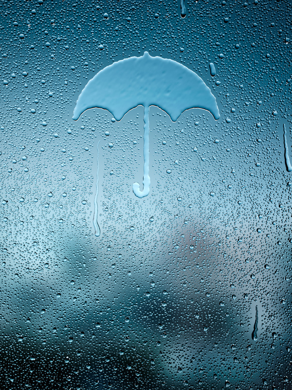 Water droplets and umbrellas on glass windows Stock Photo