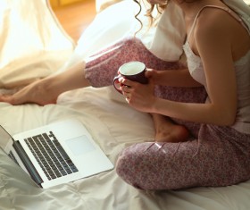 Woman in bed holding a coffee Internet Stock Photo