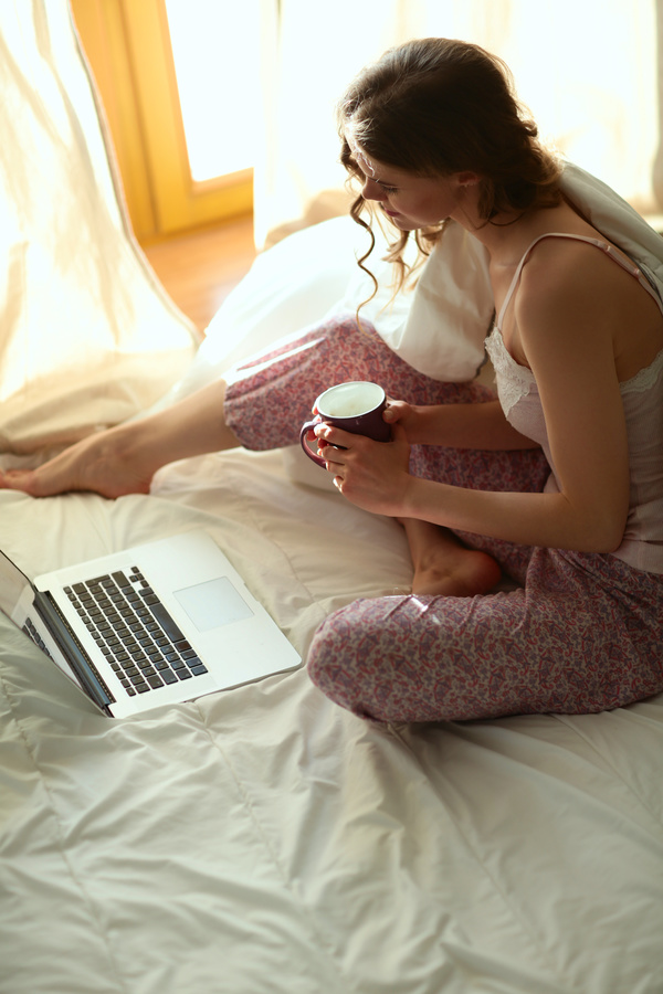 Woman in bed holding a coffee Internet Stock Photo