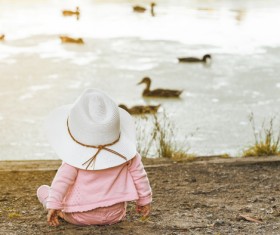 Baby sitting on the banks of the river to see the ducks HD picture
