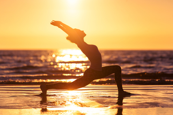 Yoga at sunrise on the beach at St Simons Island, GA Stock Photo