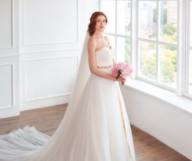 Beautiful bride standing at the window Stock Photo 01