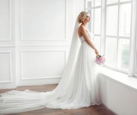 Beautiful bride standing at the window Stock Photo 02
