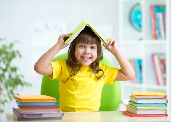 Cover a child with a book on the head Stock Photo