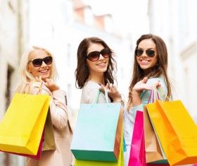 Hand shopping bags turned to smiling women Stock Photo