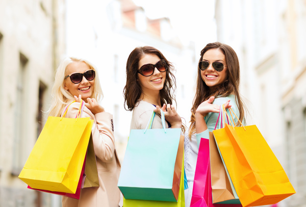 Hand shopping bags turned to smiling women Stock Photo
