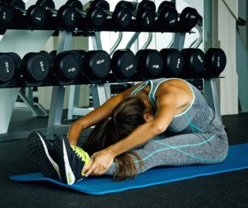 In the gym doing stretching exercises woman Stock Photo 01