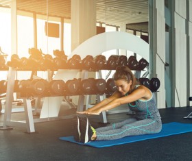 In the gym doing stretching exercises woman Stock Photo 02