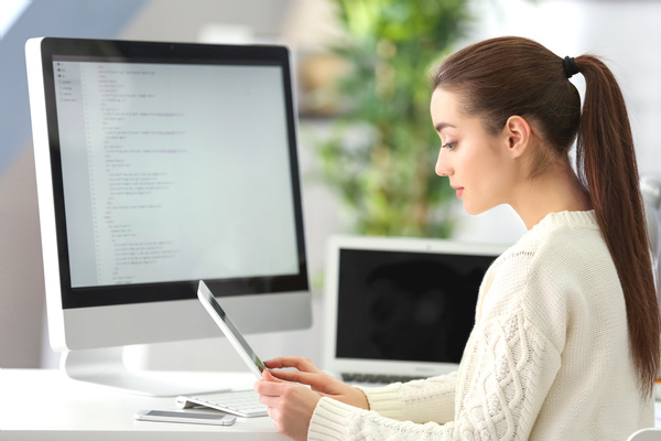 Look at the tablet of the female programmer Stock Photo