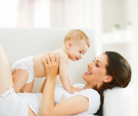 Lying on the couch and mother playing with the baby Stock Photo