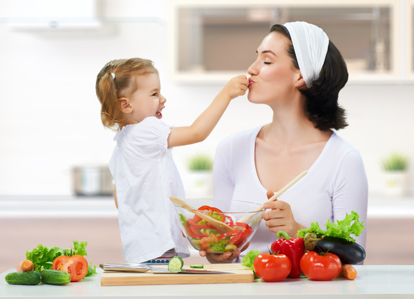 Mother kitchen cooking and naughty little girl Stock Photo