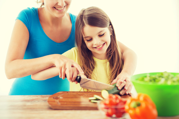 Mothers teach children to cut vegetables Stock Photo