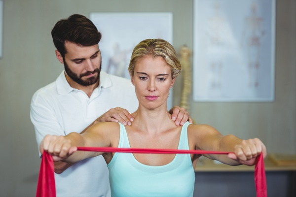Rehabilitation division instructs female patient to exercise Stock Photo