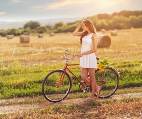 The girl pushing the bike in the field HD picture