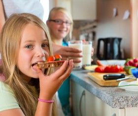The little girl in the kitchen to eat Stock Photo