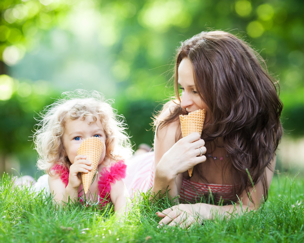 The mother and daughter who eat ice cream on the grass Stock Photo