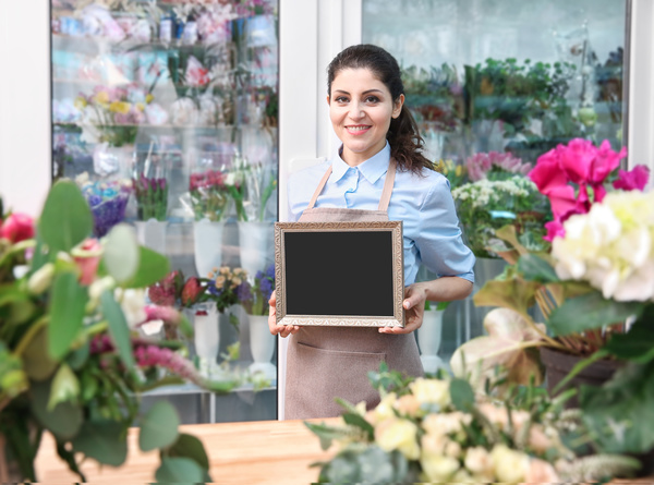 Working in a flower shop Woman hand holding a blackboard Stock Photo
