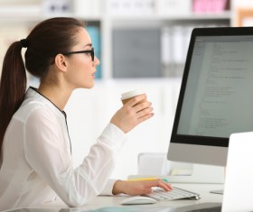 Working in the office Beautiful female programmers drinking coffee Stock Photo