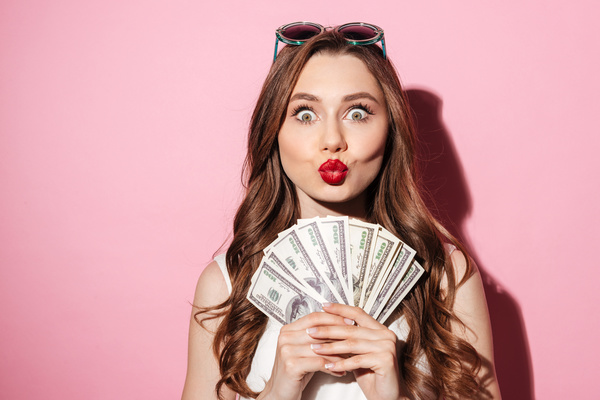Eyes wide open woman holding the dollar Stock Photo