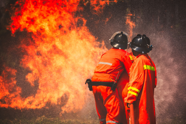 Firefighters and raging fire Stock Photo