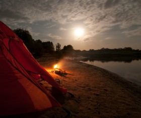 Lakeside camping tents with bonfire Stock Photo