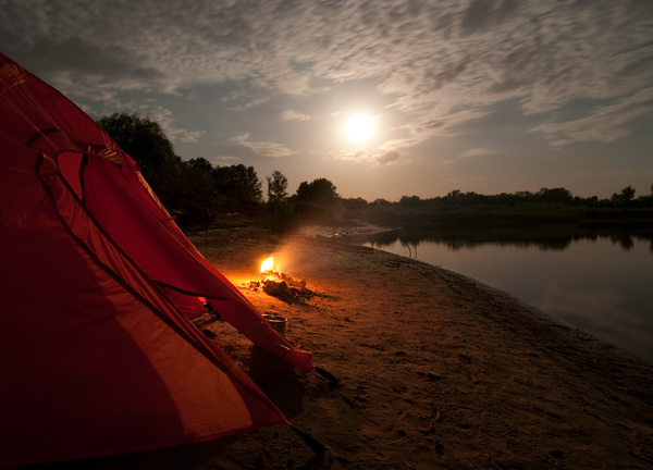 Lakeside camping tents with bonfire Stock Photo