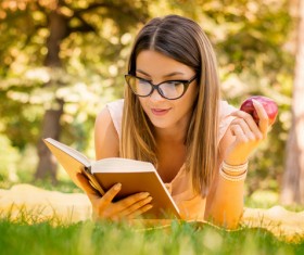 Lying in the grass to read the woman Stock Photo 01