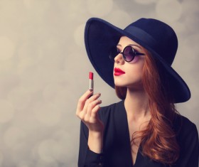Stylishly dressed woman holding a lipstick Stock Photo