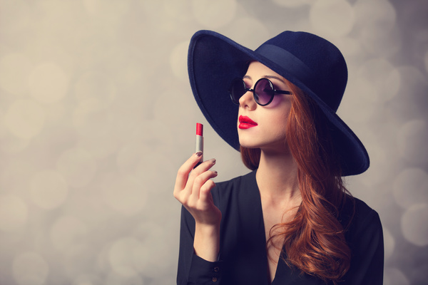 Stylishly dressed woman holding a lipstick Stock Photo