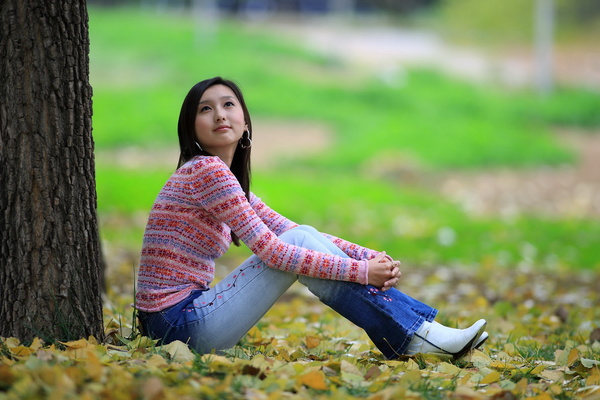The girl sitting under the tree Stock Photo