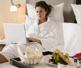 Woman leaning over the bed and breakfast online Stock Photo