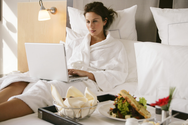 Woman leaning over the bed and breakfast online Stock Photo
