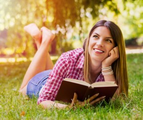 woman holding a book on the grass Stock Photo