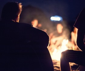 young man sitting next to the campfire Stock Photo 01