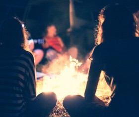 young man sitting next to the campfire Stock Photo 02