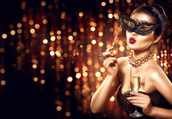 Beautiful woman holding champagne with masks Stock Photo