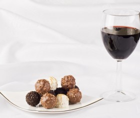 Chocolate candy and red wine on white plate Stock Photo