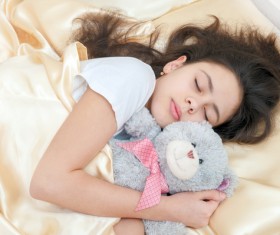The little girl who sleeps around the teddy bear Stock Photo