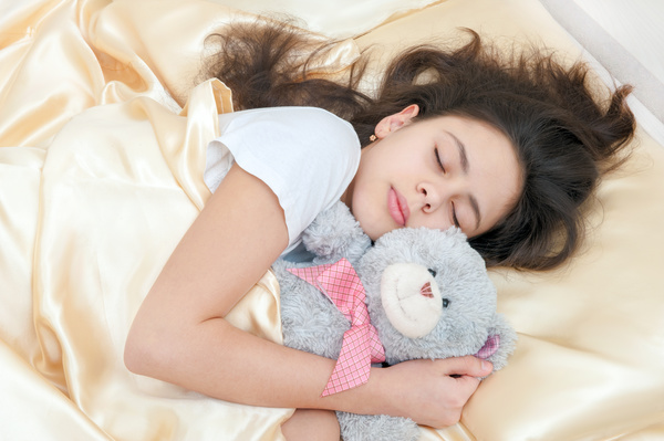 The little girl who sleeps around the teddy bear Stock Photo