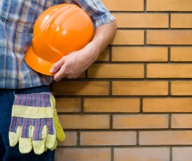 Workers standing in front of a brick wall Stock Photo