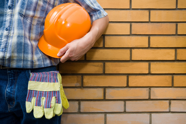 Workers standing in front of a brick wall Stock Photo