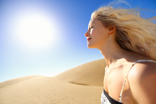 A girl with eyes closed on the sand dunes Stock Photo