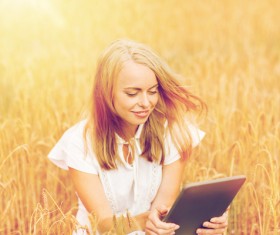 A woman using a tablet in the wheat field Stock Photo