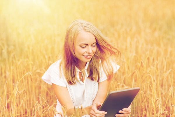 A woman using a tablet in the wheat field Stock Photo