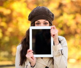 A woman who covers her face with a tablet computer Stock Photo