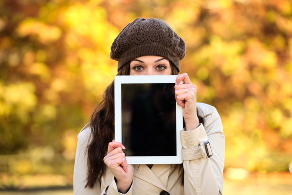 A woman who covers her face with a tablet computer Stock Photo
