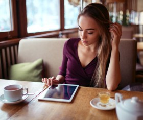 A woman who uses a tablet computer in a coffee shop Stock Photo 02